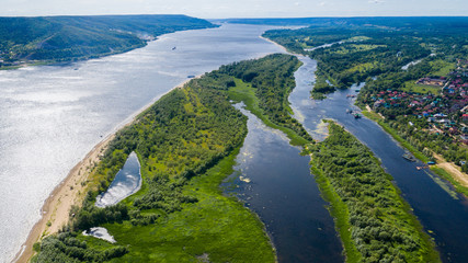 Fototapeta na wymiar Aerial view from the drone of landscape Volga river flows among the hills and fields. The middle band of Russia.