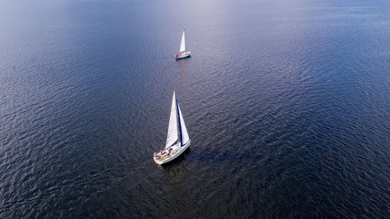 Aerial view from the drone of the yachts with white sails at sea.