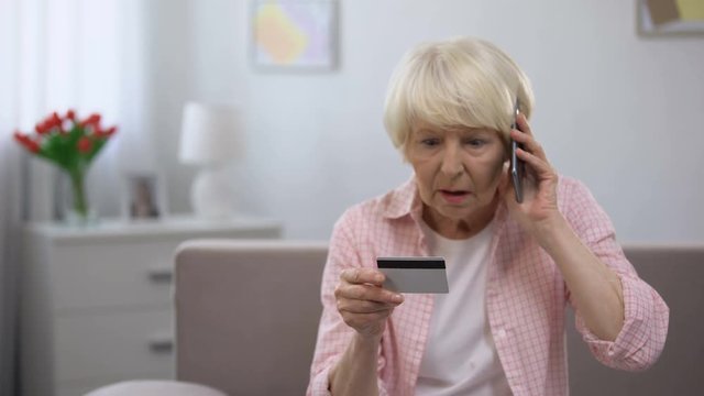 Confused senior woman with credit card calling bank support, online fraud victim