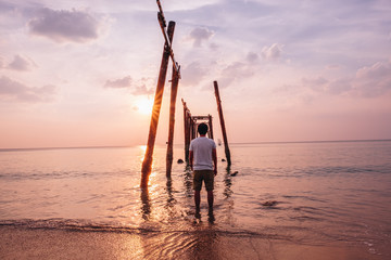 the tthe traveler see The old wooden bridge and sea wave on the raveler see The old wooden bridge and sea wave on the beach at sunset sky background at Khao Pilai, Phangnga, Thailand. Nature landscape