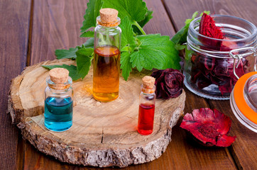 Fototapeta na wymiar Glass bottles of aroma essential oil on wooden background, image for alternative therapy medicine