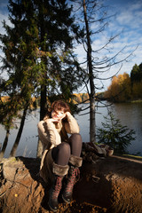 Portrait of a girl, brunette with curls, Golden autumn in a Park by the water, lake, light brown colored clothes.