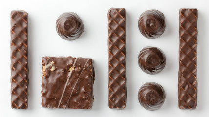 Chocolate homemade chocolates on a white paper background top wiew