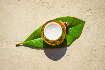 Snail and a jar of skin cream on green leaf on concrete background. Snail slime. Flat lay, top view, copy space. Beauty concept. Minimal natural layout.