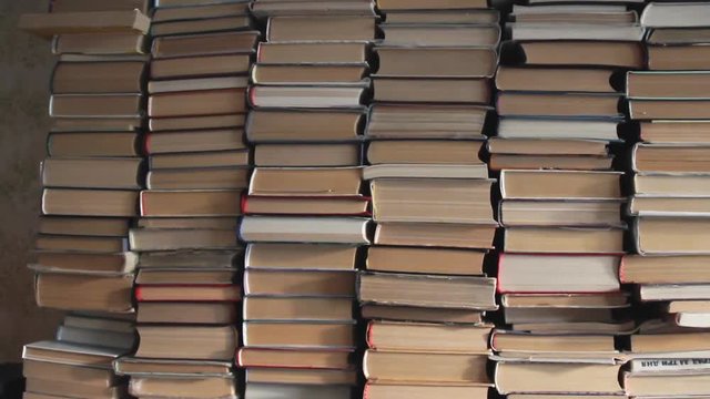 Stacks of volumes in the room. Bookworm interior. Several vertically stacked packs of manuscripts. Abandoned bookstore apartment or book depository. A big literature library. Scientific collection