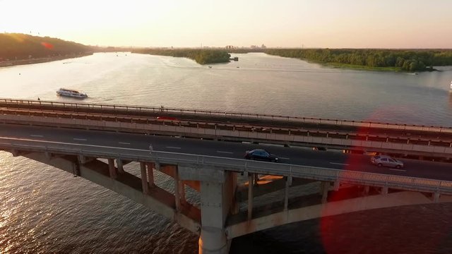 drone view Side view car rides over the bridge at sunset the camera is aimed at cars