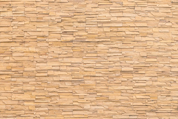 Rock stone brick tile wall aged texture detailed pattern background in dark yellow cream  brown...