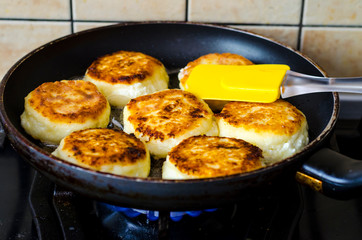 Cheesecakes curd frying and old pan. Photo