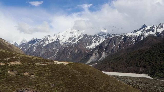 Tripod shot of fast moving clouds in Langtang Valley with the ginormous Himlayan snowcapped mountains in the background