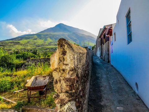 Picturesque narrow street with the volcano in the background. In Stromboli, Italy