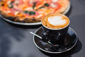Coffee cup and Traditional Italian pizza on a dark background.