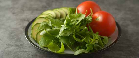 Fresh vegetables in a plate - salad mix, tomatoes and zuchinni. Healthy food concept, lose weight. Banner.