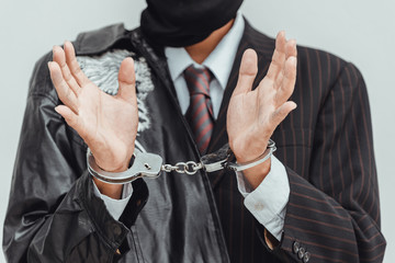 Businessman in handcuffs arrested isolated on gray background