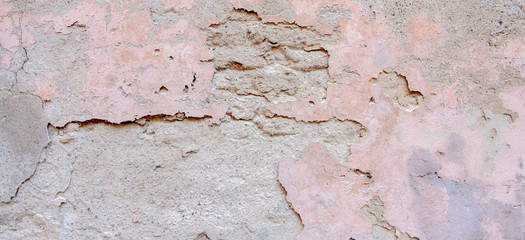 Old weathered painted wall background texture. Light grey pink dirty peeled plaster wall with falling off flakes of paint