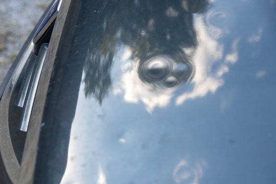 Motorhaube eines grauen PKW mit Hagelschaden zeigt nach einem Hagelschauer viele Dellen und Beulen in der Motorhaube f&uuml;r die Versicherung