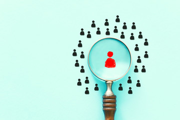 business image of magnifying glass with people icon over mint table, building a strong team, human...