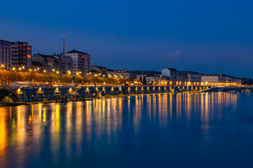 Fototapeta na wymiar Aerial night dark view on Turin city center, the Murazzi street on the river Po is illuminated by lights. Torino, Piedmont, Italy