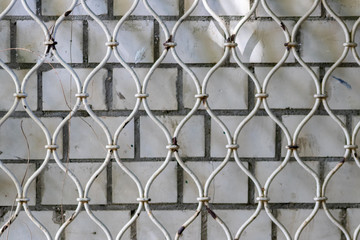 Geschmiedeter Metallzaun mit schönem Muster dient als Metalltor und weißes Rankgitter für...