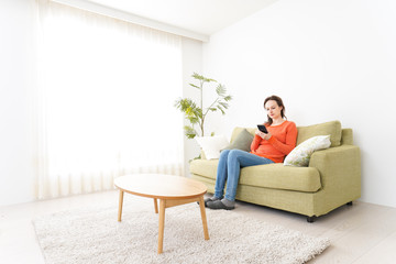 家でスマホを使う若い女性