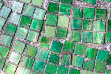 Nahaufnahme eines grünen Mosaik aus unterschiedlich großen Mosaiksteinchen und Kacheln zeigen ein...