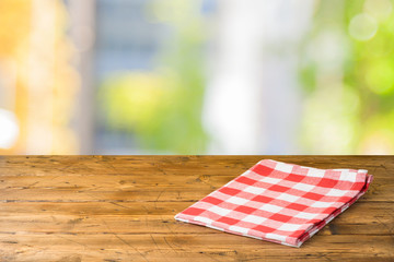 Obraz premium Empty wooden table with tablecloth over abstract bokeh background