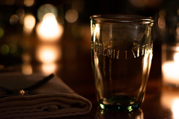 Dark French Bistro Restaurant In Newport, Rhode Island Wooden Table With Candles, Glasses and Place...