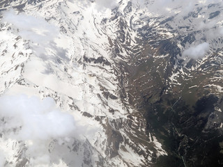 Aerial view of the cloudy Alps between Swiss and Italy seen on a flight
