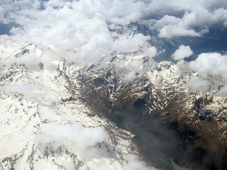 Aerial view of the cloudy Alps between Swiss and Italy seen on a flight