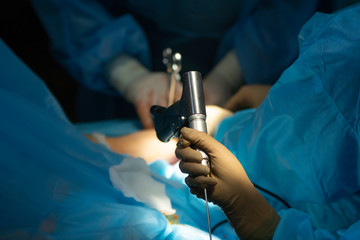 Surgical drill handed to surgeon closeup with shallow depth of field