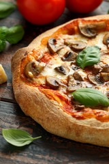 Hot Mushroom Pizza with basil, tomatoes, mozzarella and parmesan cheese on wooden table. ready to eat. vegetarian food