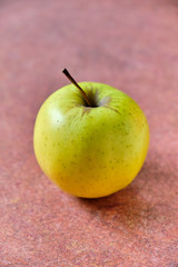 Green apple lying on red background