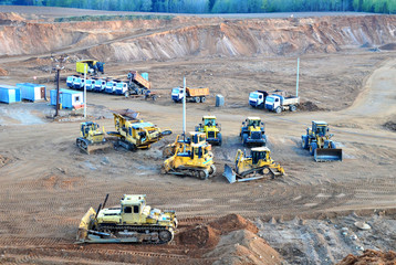 Obraz na płótnie Canvas A lot of heavy construction equipment in the mining quarry. Parking with bulldozers, tractors, front loaders, excavators and dump trucks, top view - Image