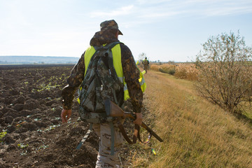 Hunter with a german drathaar and spaniel, pigeon hunting with dogs in reflective vests	