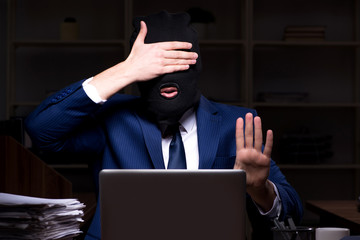 Male employee stealing information in the office night time  