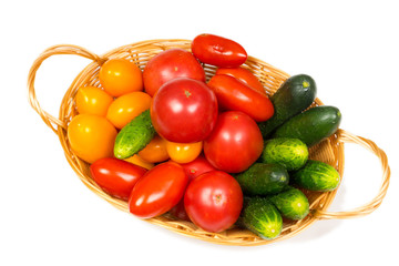 fresh tomatoes and cucumbers in basket isolated on white background