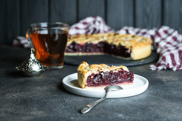 Homemade delicious cherry pie on a dark background.