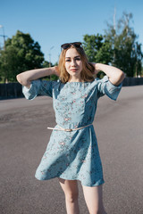 young and smiling girl is actively moving on a Sunny summer day. a woman with sunglasses on her...