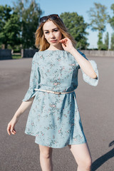 young and smiling girl is actively moving on a Sunny summer day. a woman with sunglasses on her...