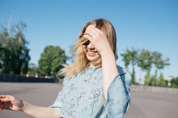 young and smiling girl is actively moving on a Sunny summer day. a woman with sunglasses on her...