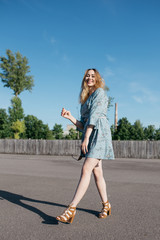 young and smiling girl is actively moving on a Sunny summer day. a woman with sunglasses on her...