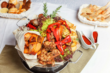 Mixed grill meat, fried vegetables and grilled salmon fish fillets decoration in warm dish. Assorted delicious grilled kebab served with herbs on platter. Restaurant menu plate