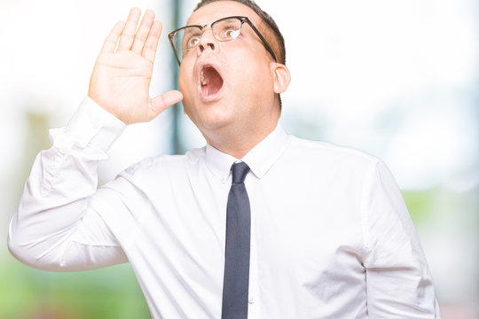 Middle age bussines arab man wearing glasses over isolated background shouting and screaming loud to side with hand on mouth. Communication concept.