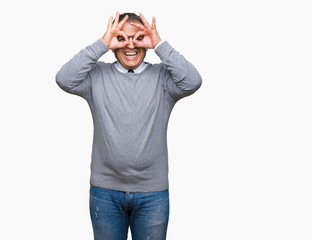 Middle age bussines arab man wearing glasses over isolated background doing ok gesture like binoculars sticking tongue out, eyes looking through fingers. Crazy expression.