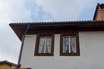 Fragment of painted in bright color house with wooden windows and picturesque eaves, Koprivshtitsa, Bulgaria, Europe