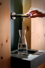 tap water flowing into a glass carafe