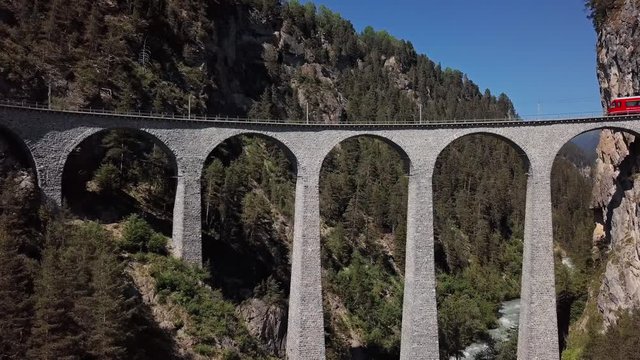 Aerial panorama of Swiss red train on famous Landwasser Viaduct (Landwasserviadukt), Graubunden, Switzerland.
