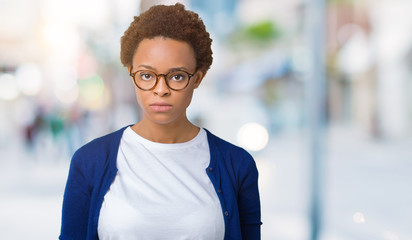 Young beautiful african american woman wearing glasses over isolated background skeptic and nervous, frowning upset because of problem. Negative person.