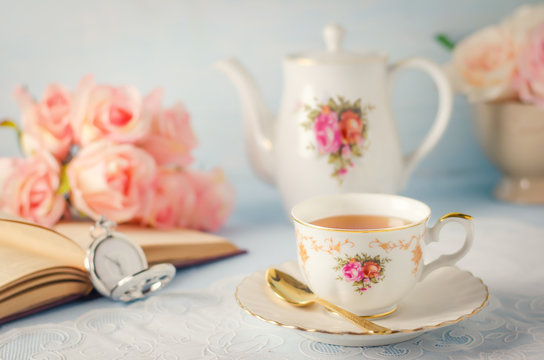 Cup of tea with teapot and flowers with vintage tone