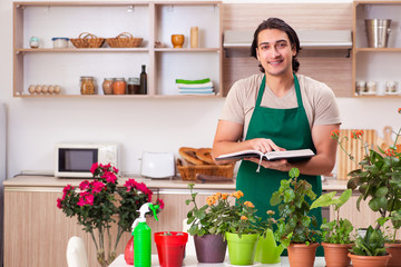 Young handsome man cultivating flowers at home