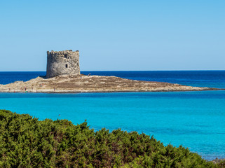 Fototapeta na wymiar La Pelosa Beach in Stintino, Sardinia, Italy. In the background, the landmark 16th century La Pelosa Tower (Italian: Torre della Pelosa).